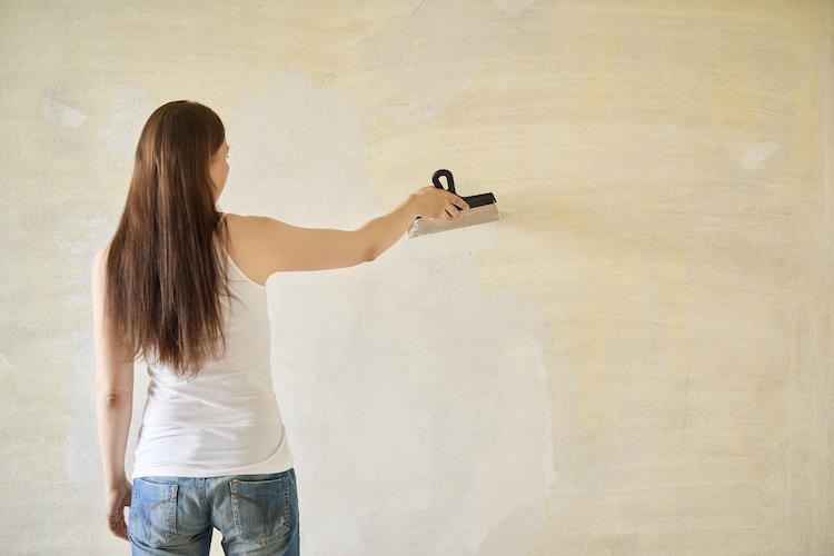 Woman,Plastering,The,Walls,With,Finishing,Putty,In,The,Room foot pain massage treatment